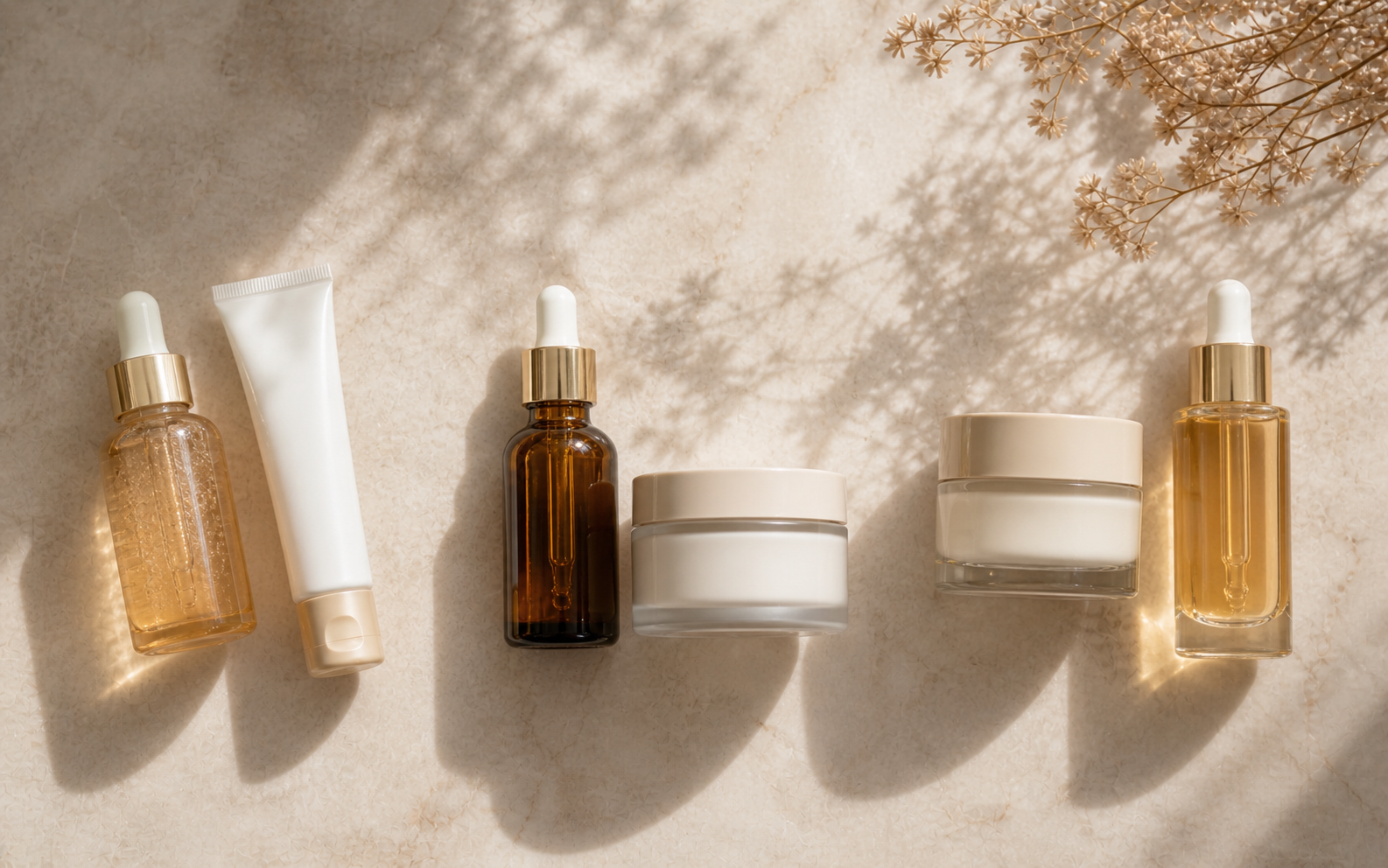 Three serums lined up side by side on a warm linen surface, suggesting different routines for different ages