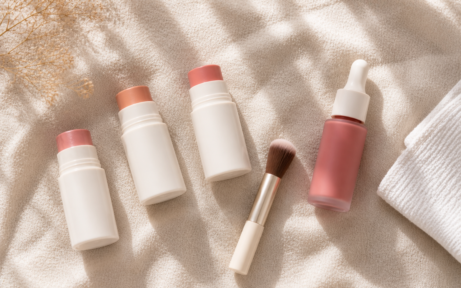 A few blush compacts in soft pink and rose tones opened gently on a cream surface