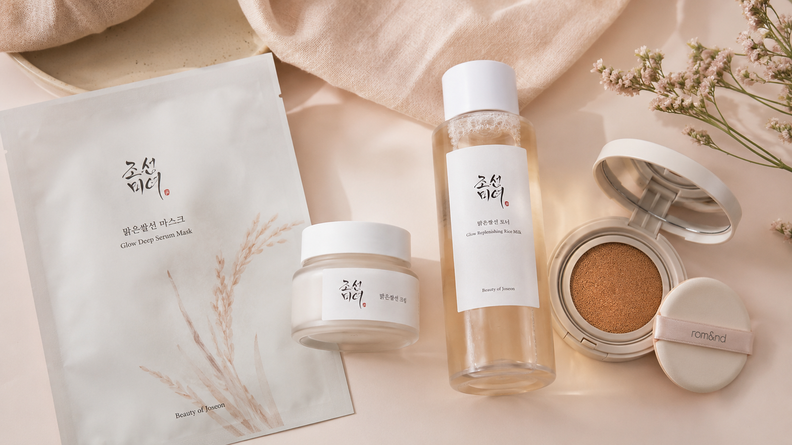 A flat-lay arrangement of Korean skincare products on a soft pastel surface