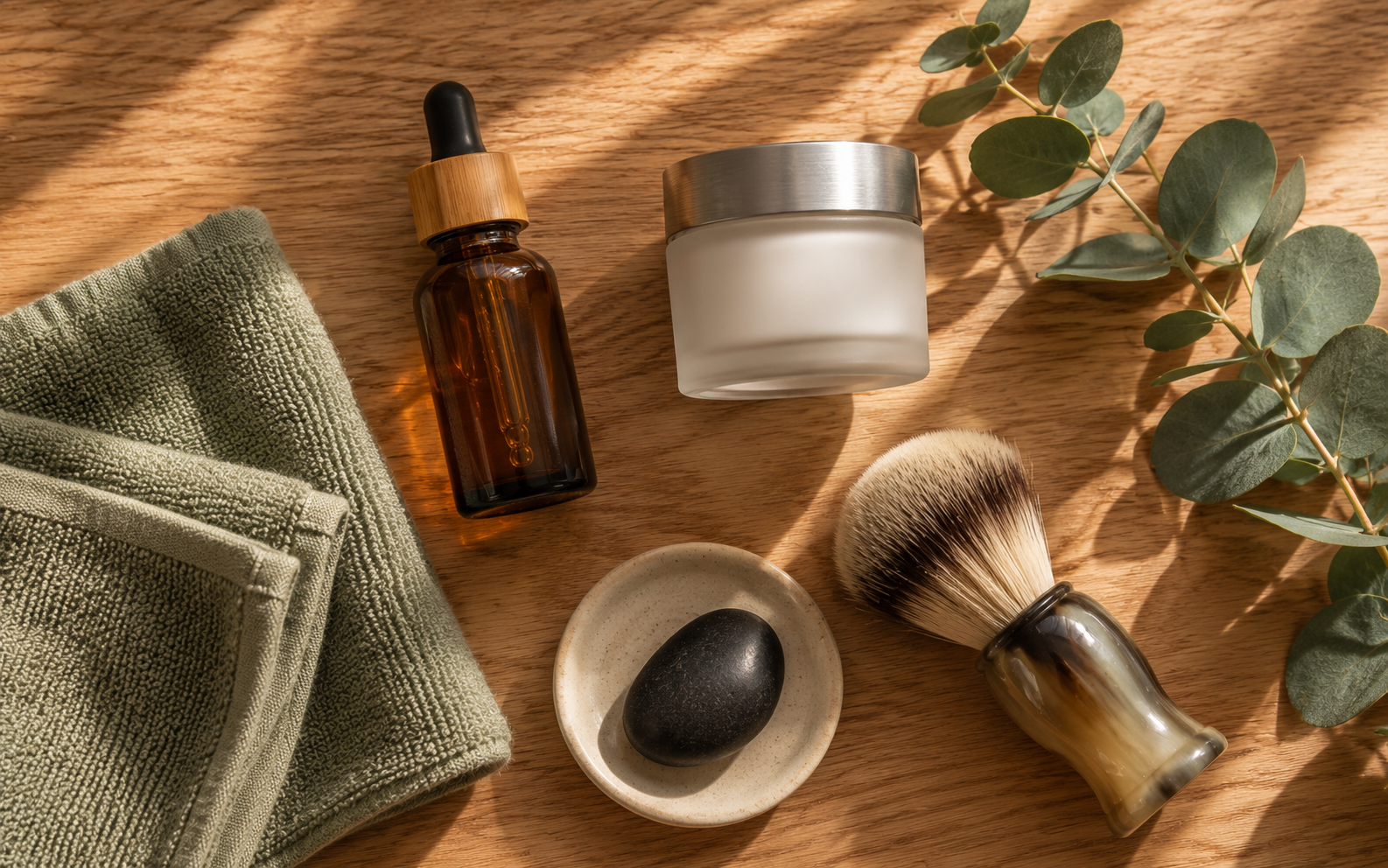 A few simple men's skincare bottles arranged minimally on a smooth slate surface