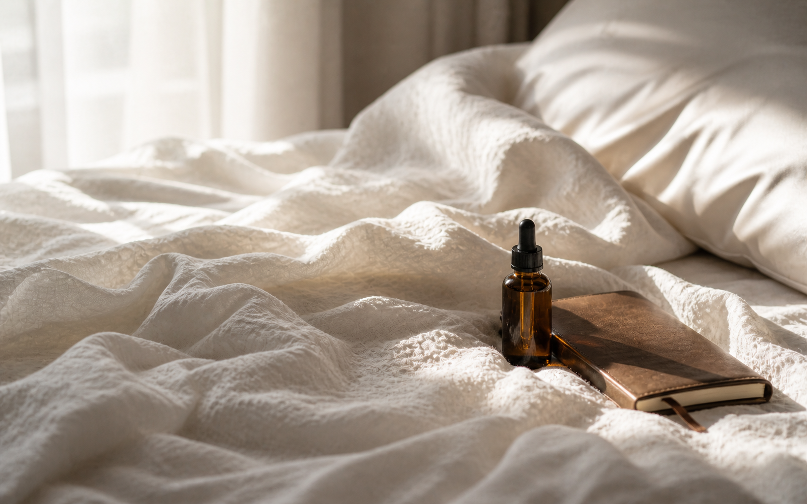 A softly made bed with morning light filtering through sheer linen curtains